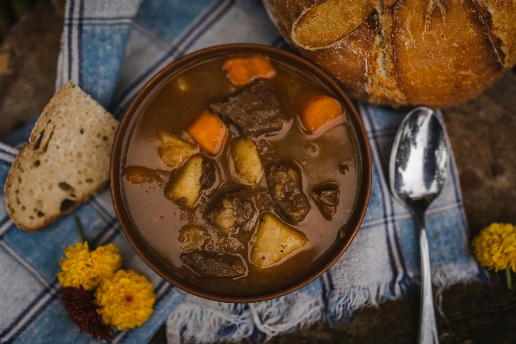 Bowl of beef stew served with bread and a spoon